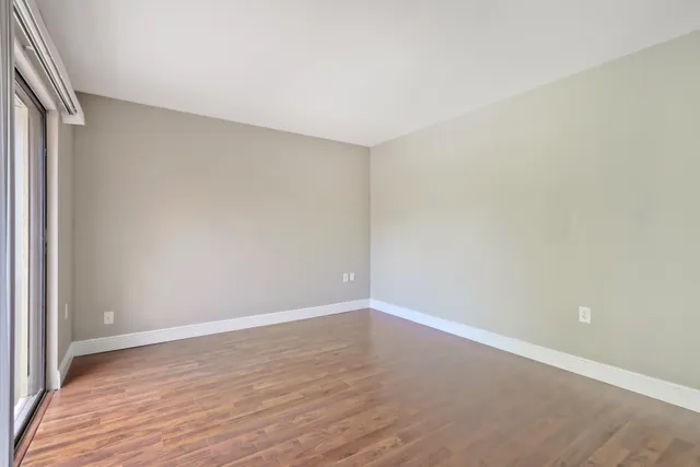 a view of an empty room with wooden floor
