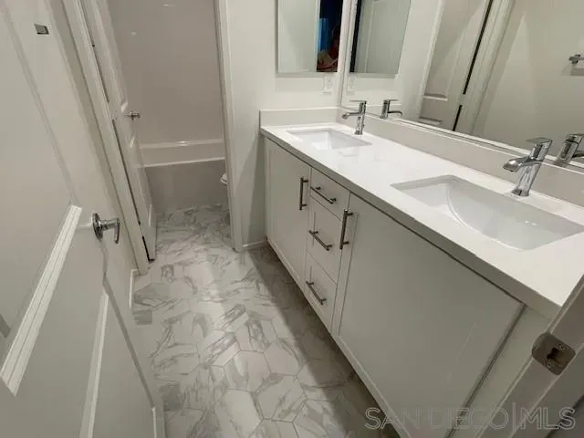 a bathroom with a double vanity sink and mirror