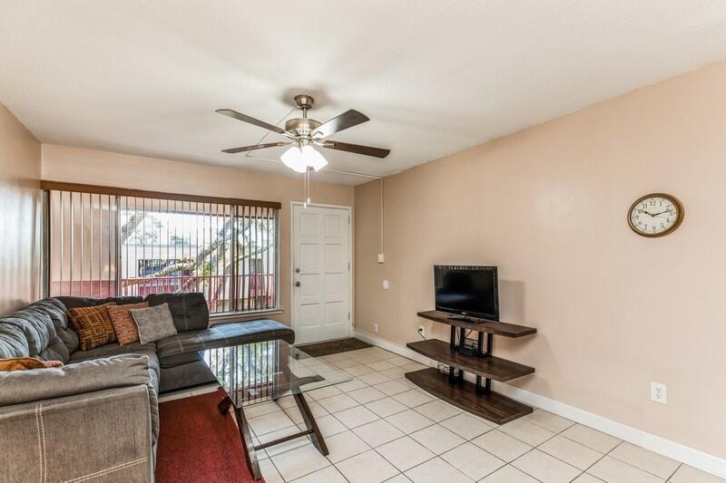 210 Pelham Road, Unit 201A Fort Walton Beach, FL 32547 - Photo 11 of 38 a living room with furniture and a flat screen tv