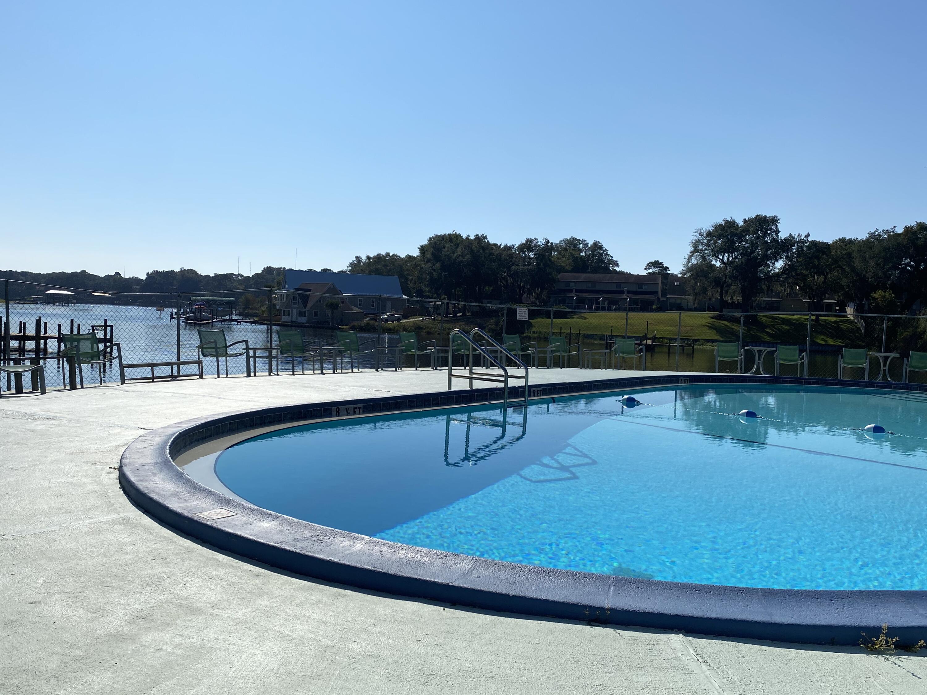 210 Pelham Road, Unit 201A Fort Walton Beach, FL 32547 - Photo 2 of 38 a view of swimming pool with lake and mountain in the back