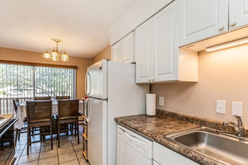 210 Pelham Road, Unit 201A Fort Walton Beach, FL 32547 - Photo 21 of 38 a kitchen with stainless steel appliances granite countertop a sink refrigerator and cabinets