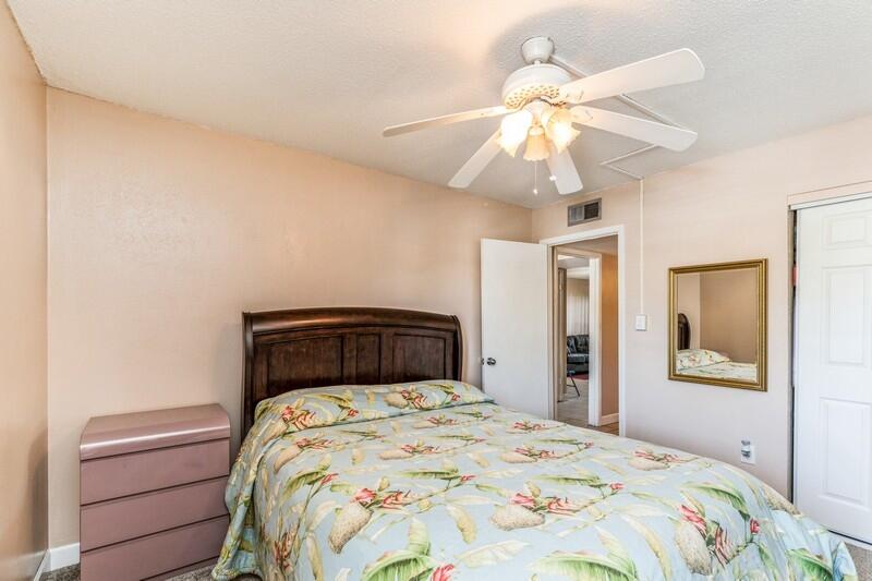 210 Pelham Road, Unit 201A Fort Walton Beach, FL 32547 - Photo 26 of 38 a bedroom with a bed and a chandelier