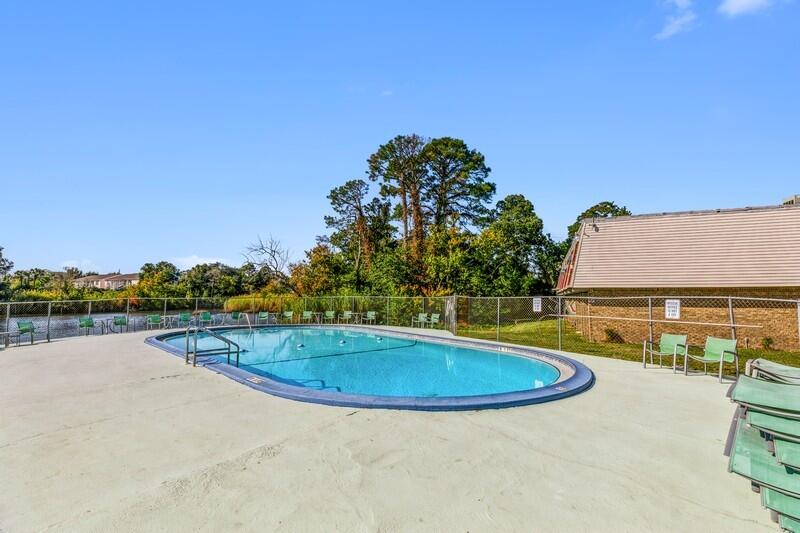 210 Pelham Road, Unit 201A Fort Walton Beach, FL 32547 - Photo 32 of 38 a view of a swimming pool with an outdoor seating and a yard