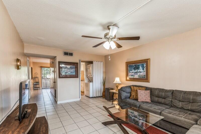 210 Pelham Road, Unit 201A Fort Walton Beach, FL 32547 - Photo 8 of 38 a living room with furniture and a flat screen tv