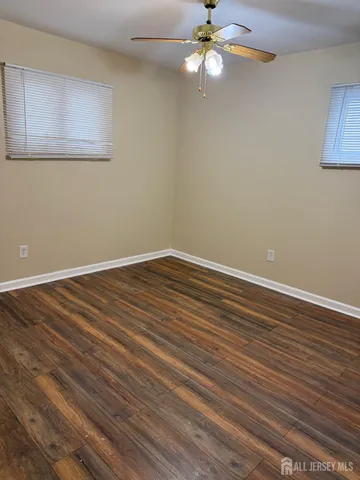 a view of room with wooden floor and ceiling fan