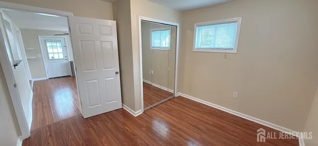 an empty room with wooden floor and closet