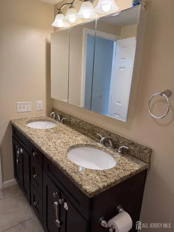 a bathroom with a granite countertop sink and a mirror