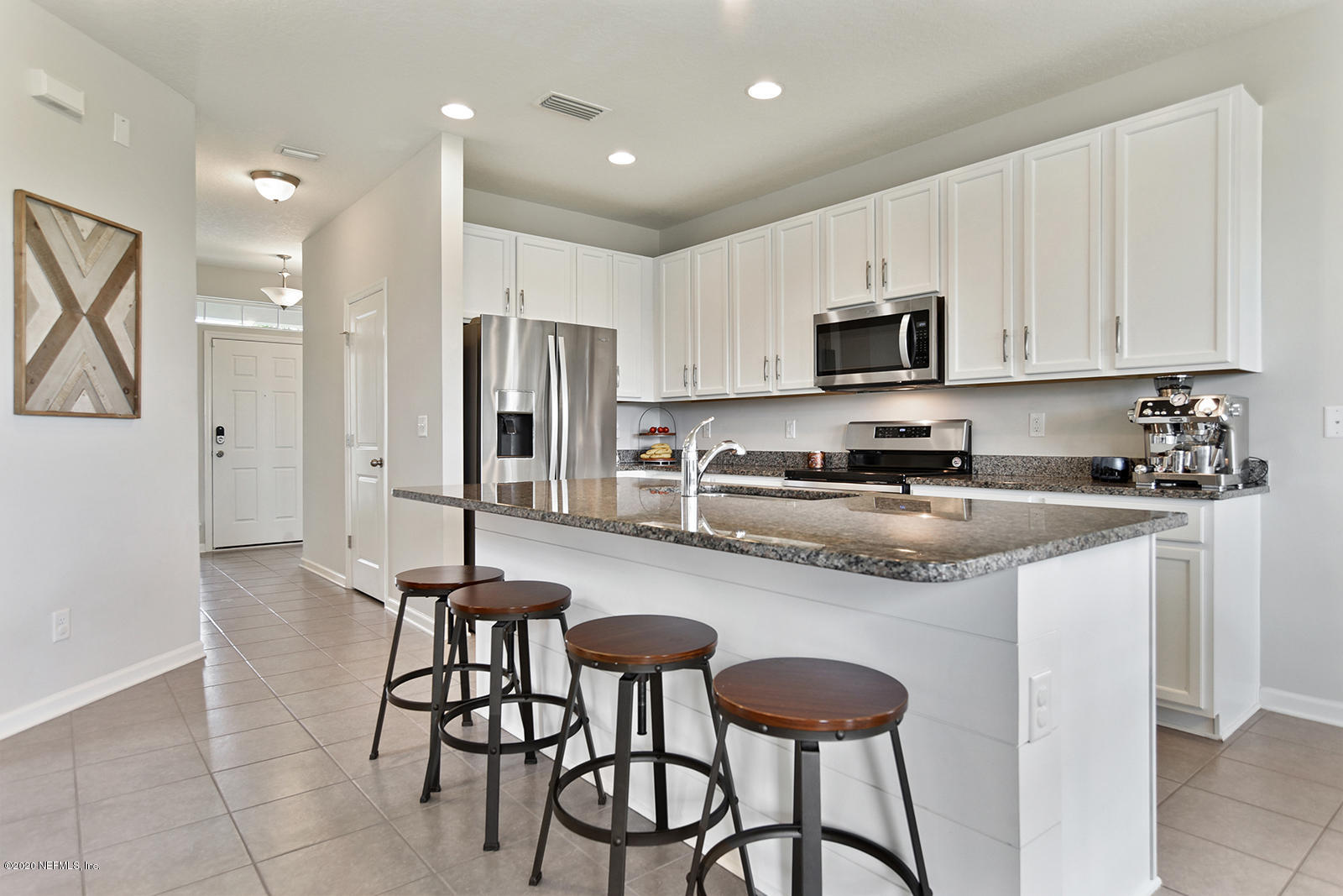 14780 Trellis Street Jacksonville, FL 32258 - Photo 6 of 29 a kitchen with stainless steel appliances granite countertop a stove top oven a refrigerator a sink and a dining table with white cabinets
