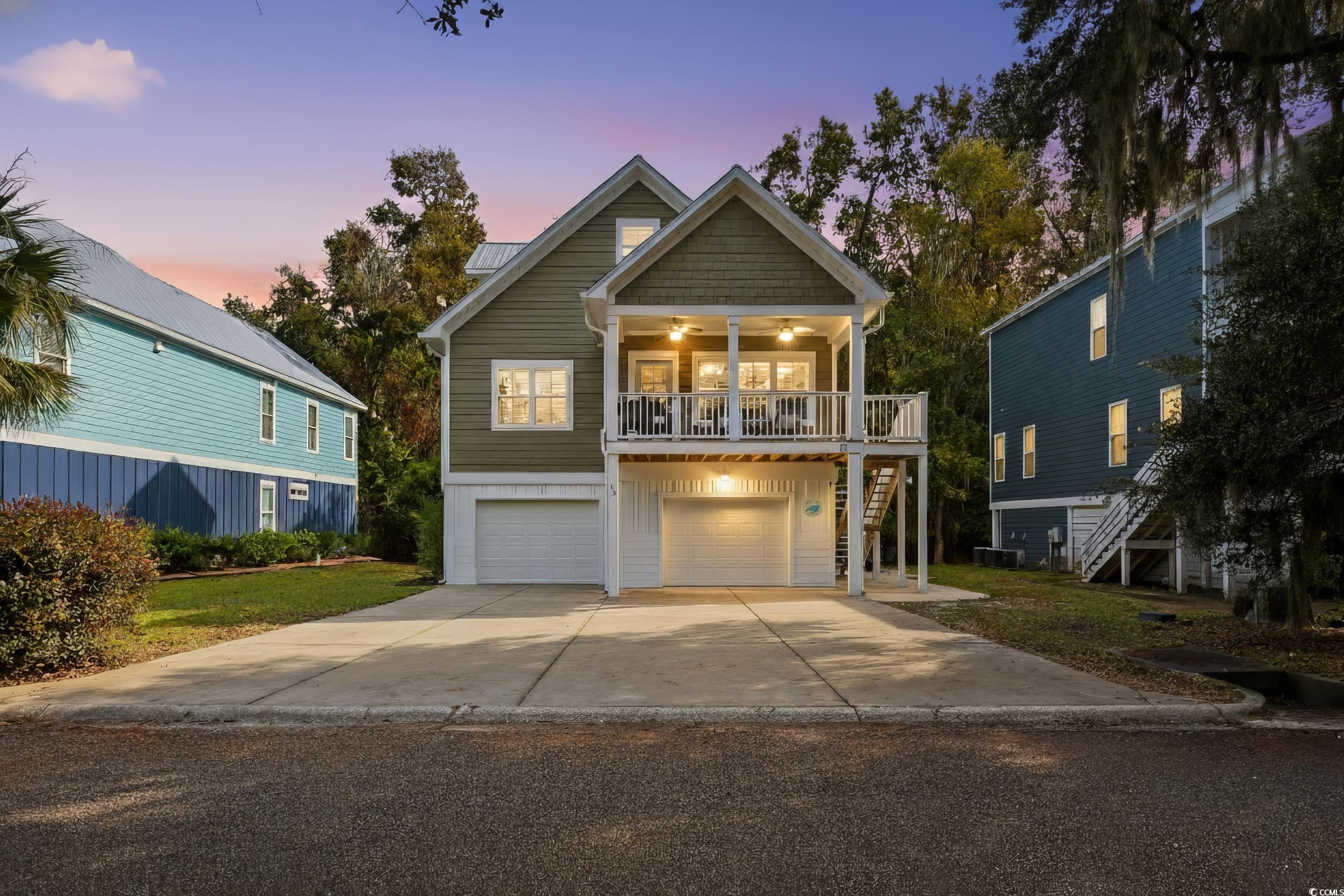 43 Sandlapper Way Pawleys Island, SC 29585 - Photo 1 of 33 Coastal inspired home with stairs, driveway, a balcony, an attached garage, and a ceiling fan