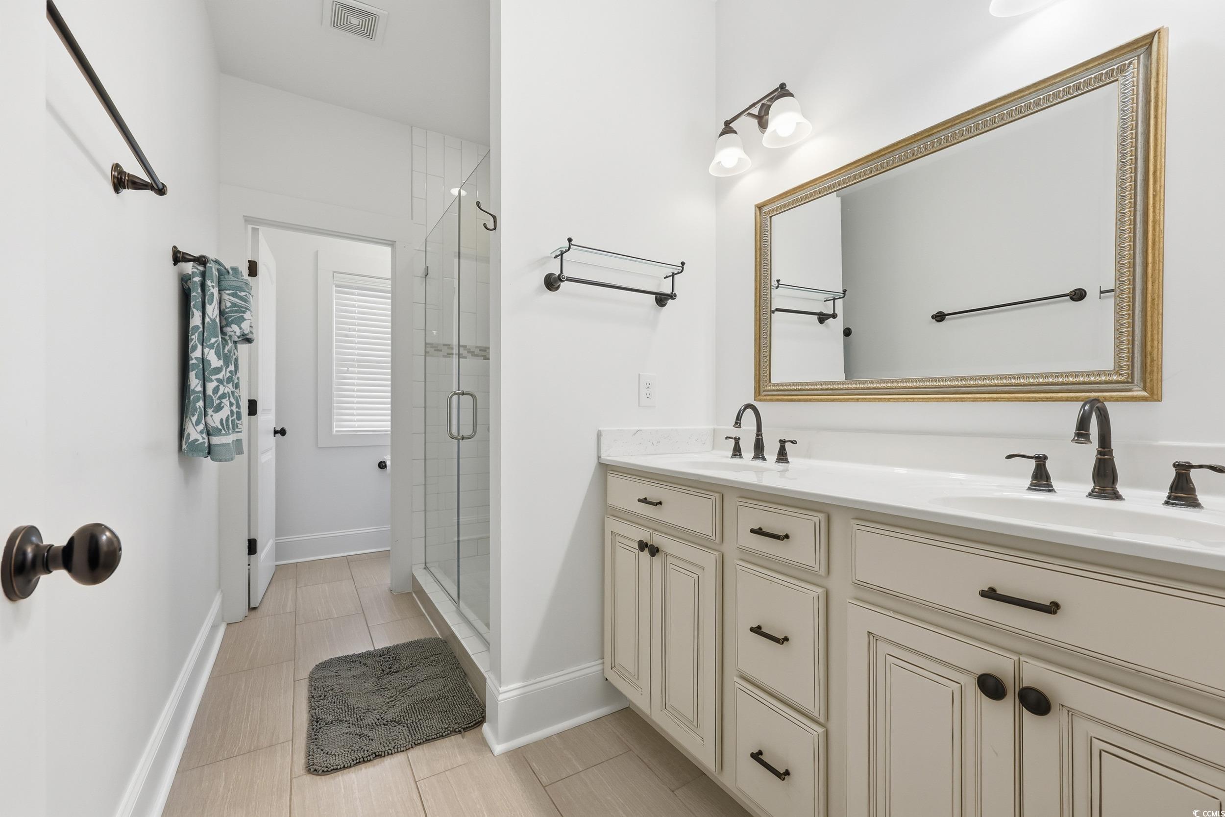 43 Sandlapper Way Pawleys Island, SC 29585 - Photo 14 of 33 Full bathroom with double vanity, a shower stall, and light tile patterned flooring