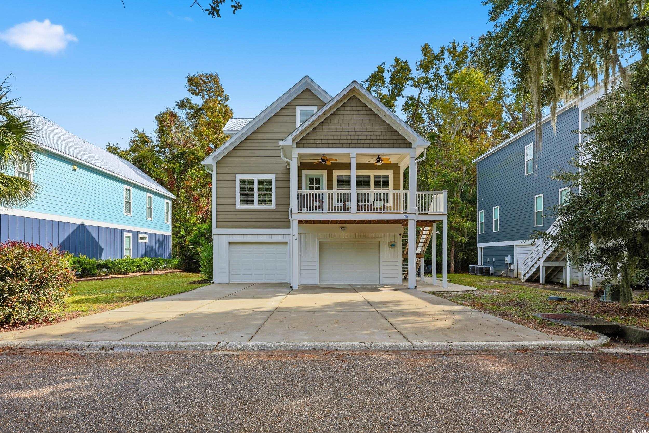 43 Sandlapper Way Pawleys Island, SC 29585 - Photo 2 of 33 Coastal inspired home with a ceiling fan, stairs, driveway, and an attached garage