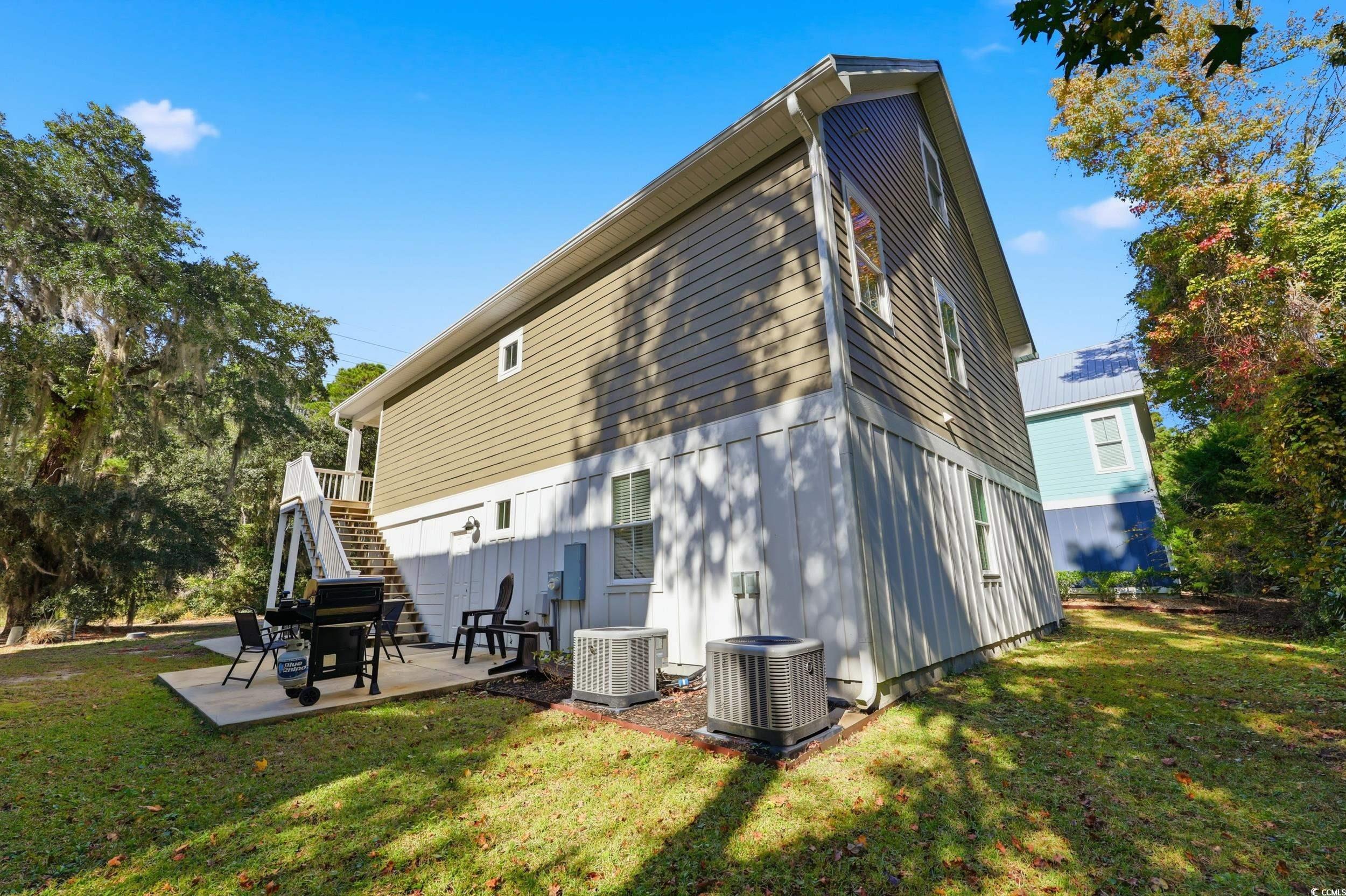 43 Sandlapper Way Pawleys Island, SC 29585 - Photo 25 of 33 Rear view of house featuring stairway, a yard, and a patio area