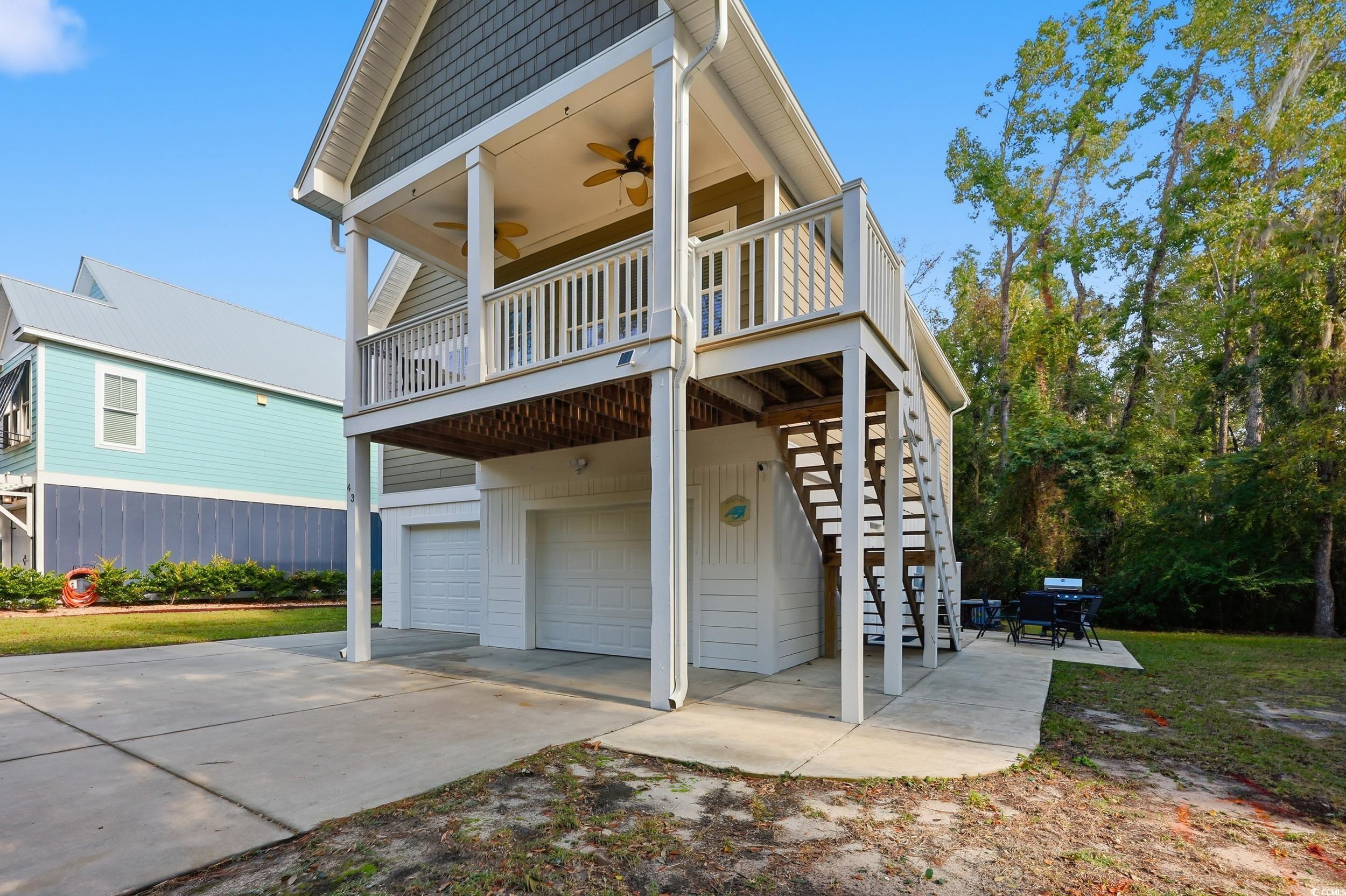 43 Sandlapper Way Pawleys Island, SC 29585 - Photo 26 of 33 View of front of house featuring a ceiling fan, a garage, stairway, a patio area, and a deck