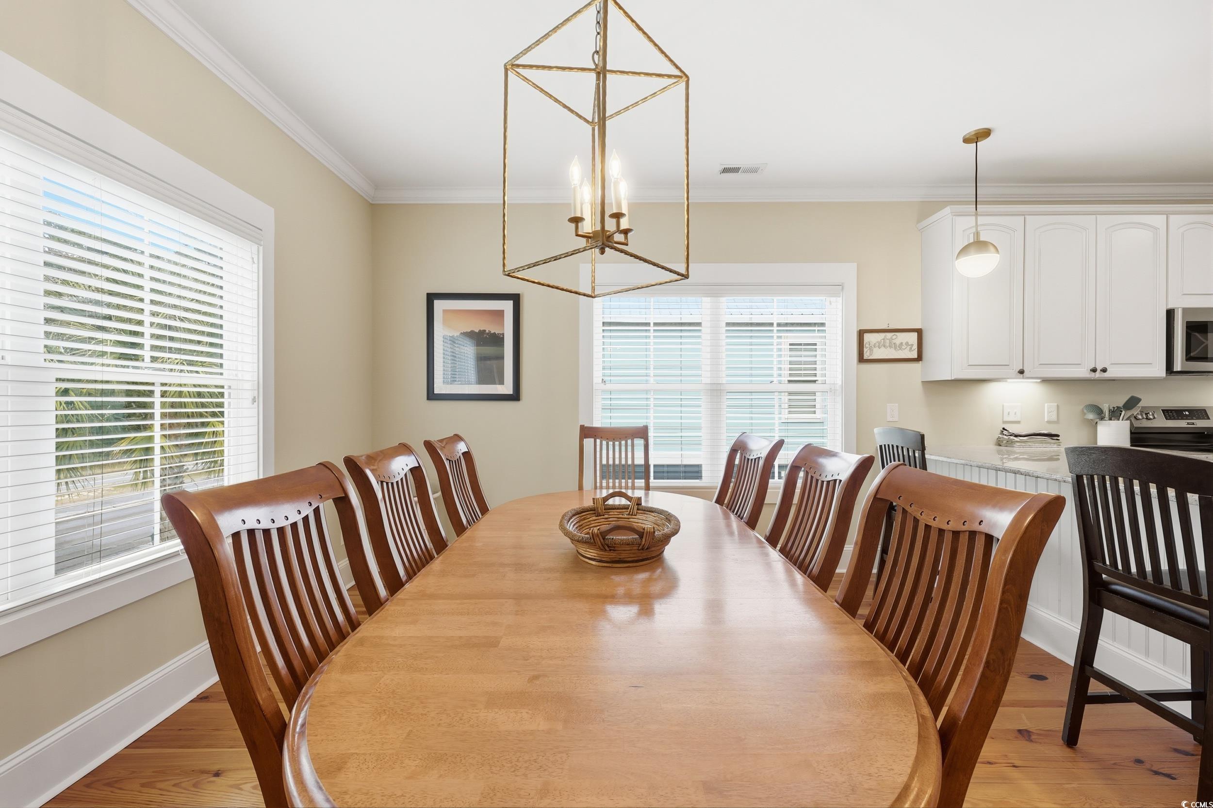 43 Sandlapper Way Pawleys Island, SC 29585 - Photo 6 of 33 Dining room with ornamental molding, light wood-style floors, and a chandelier