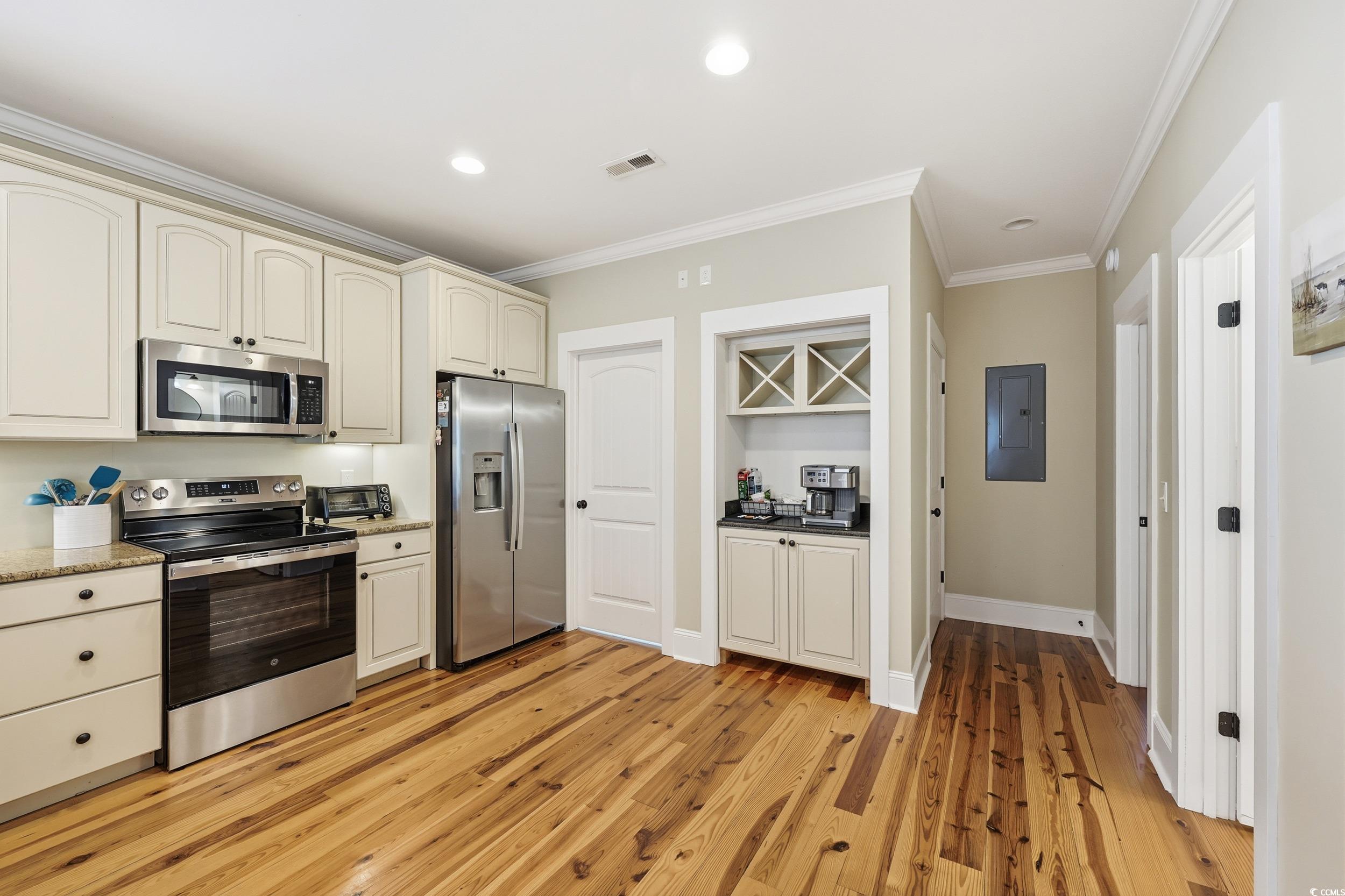 43 Sandlapper Way Pawleys Island, SC 29585 - Photo 10 of 33 Kitchen featuring cream cabinets, appliances with stainless steel finishes, recessed lighting, ornamental molding, and light wood finished floors