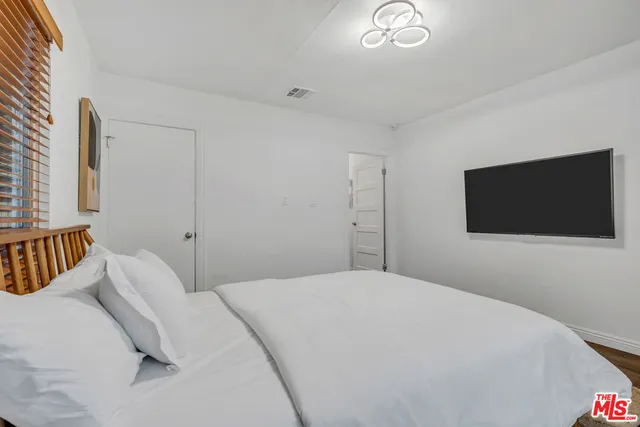 a bedroom with a bed and a flat screen tv