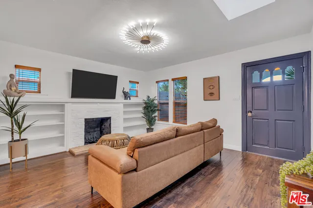 a living room with furniture a fireplace and a potted plant