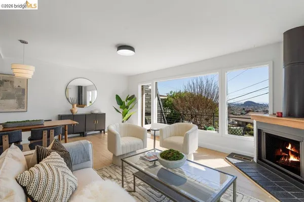 a living room with furniture a large window and a dining table