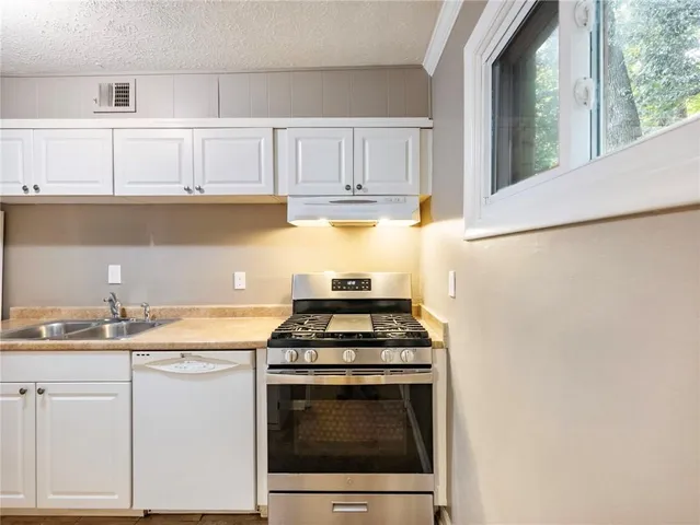 a kitchen with granite countertop a sink stove and refrigerator