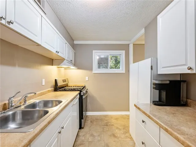 a kitchen with a refrigerator sink and cabinets