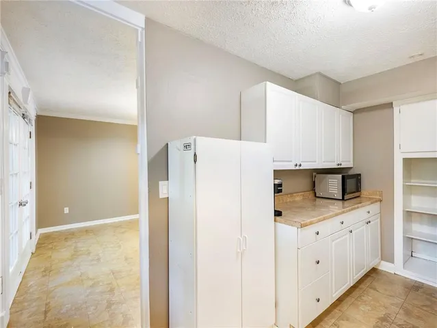a kitchen with white cabinets and appliances