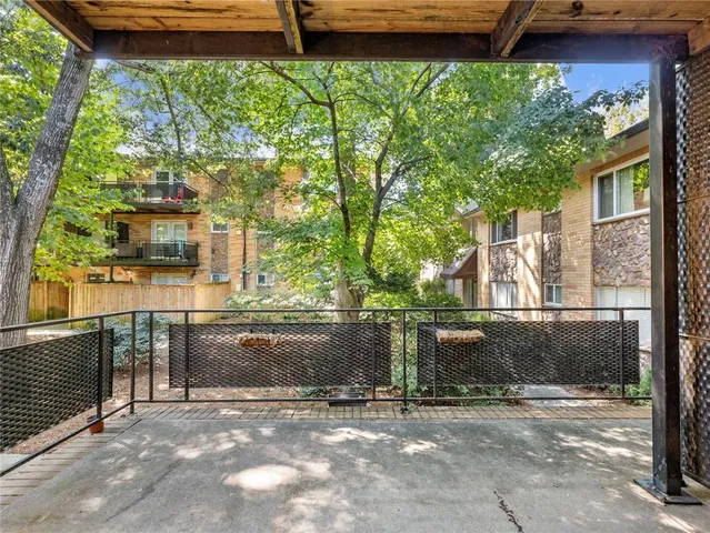 a view of a room with wooden chairs and a tree
