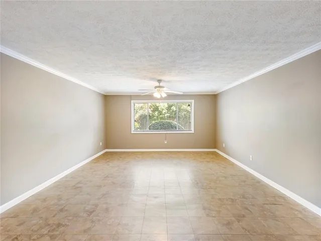 an empty room with a ceiling fan and a window