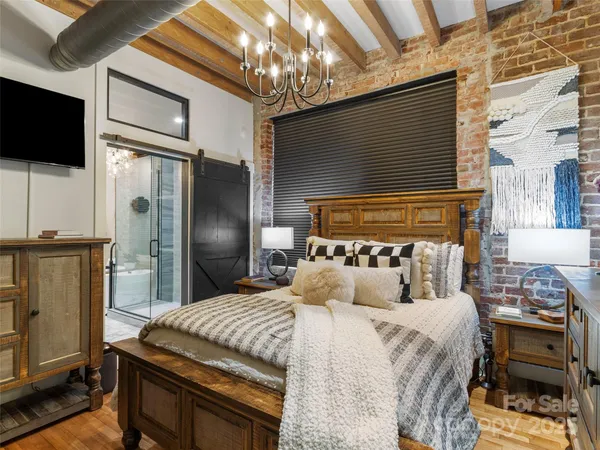 a bedroom with a bed tv and a fireplace