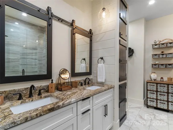 a bathroom with a granite countertop sink a mirror and shower