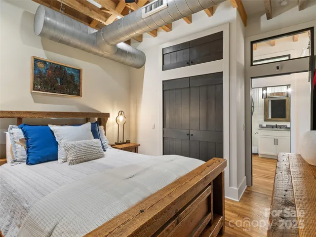 a bedroom with a bed and a wall painting