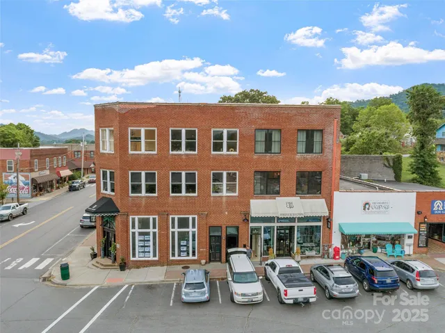 an aerial view of residential houses with outdoor space and street view