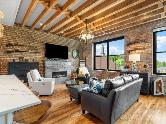 a living room with furniture a fireplace and a flat screen tv