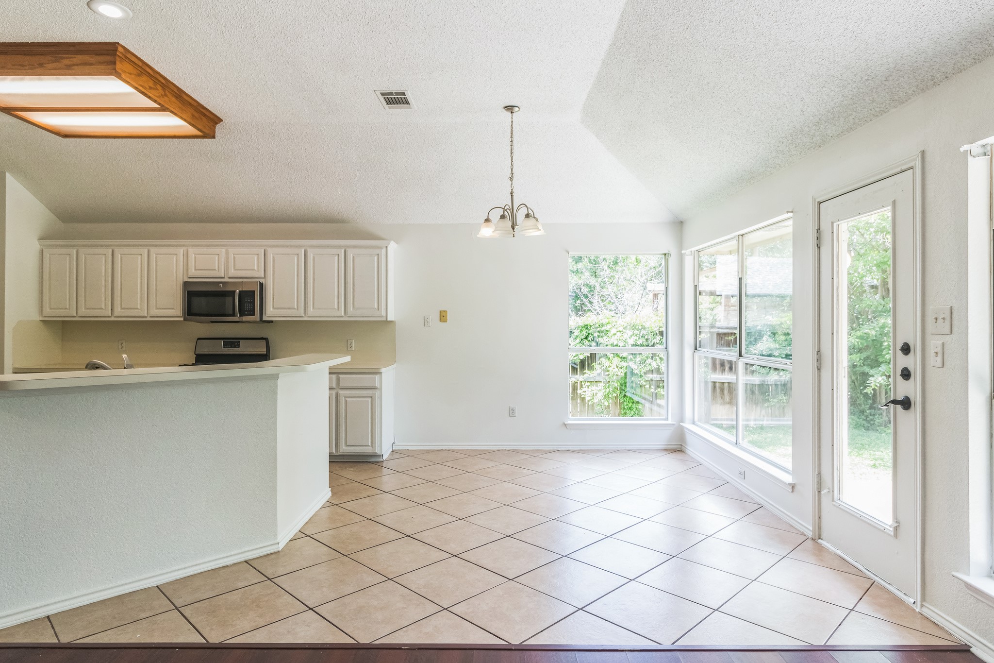 800 Mountain Ridge Drive Leander, TX 78641 - Photo 10 of 31 Tiled flooring flows through an airy breakfast area open to the kitchen.
