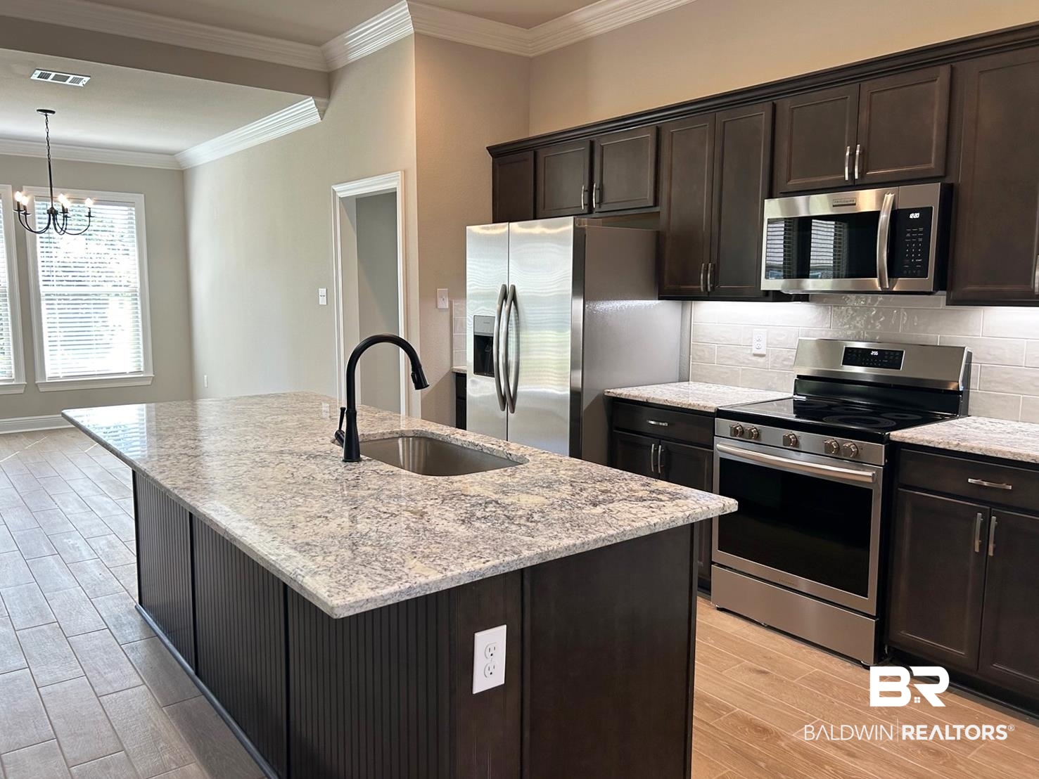 848 Sumter Loop Foley, AL 36535 - Photo 2 of 16 Kitchen featuring a center island with sink, sink, appliances with stainless steel finishes, light hardwood / wood-style floors, and tasteful backsplash