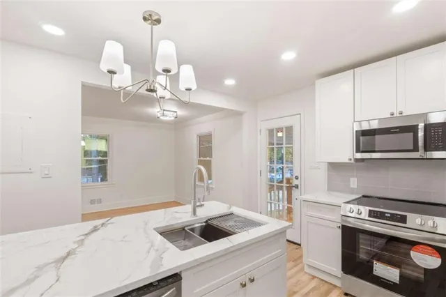 a bathroom with a granite countertop sink a mirror and a bathtub