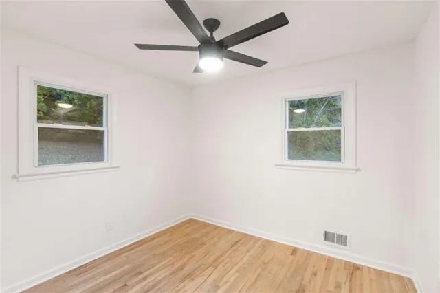 a bedroom with a bed wooden floor and window