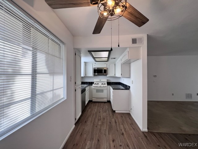 1190 Ramar Road, Unit 46 Bullhead City, AZ 86442 - Photo 13 of 36 a kitchen with stainless steel appliances a stove a refrigerator and white cabinets with wooden floor