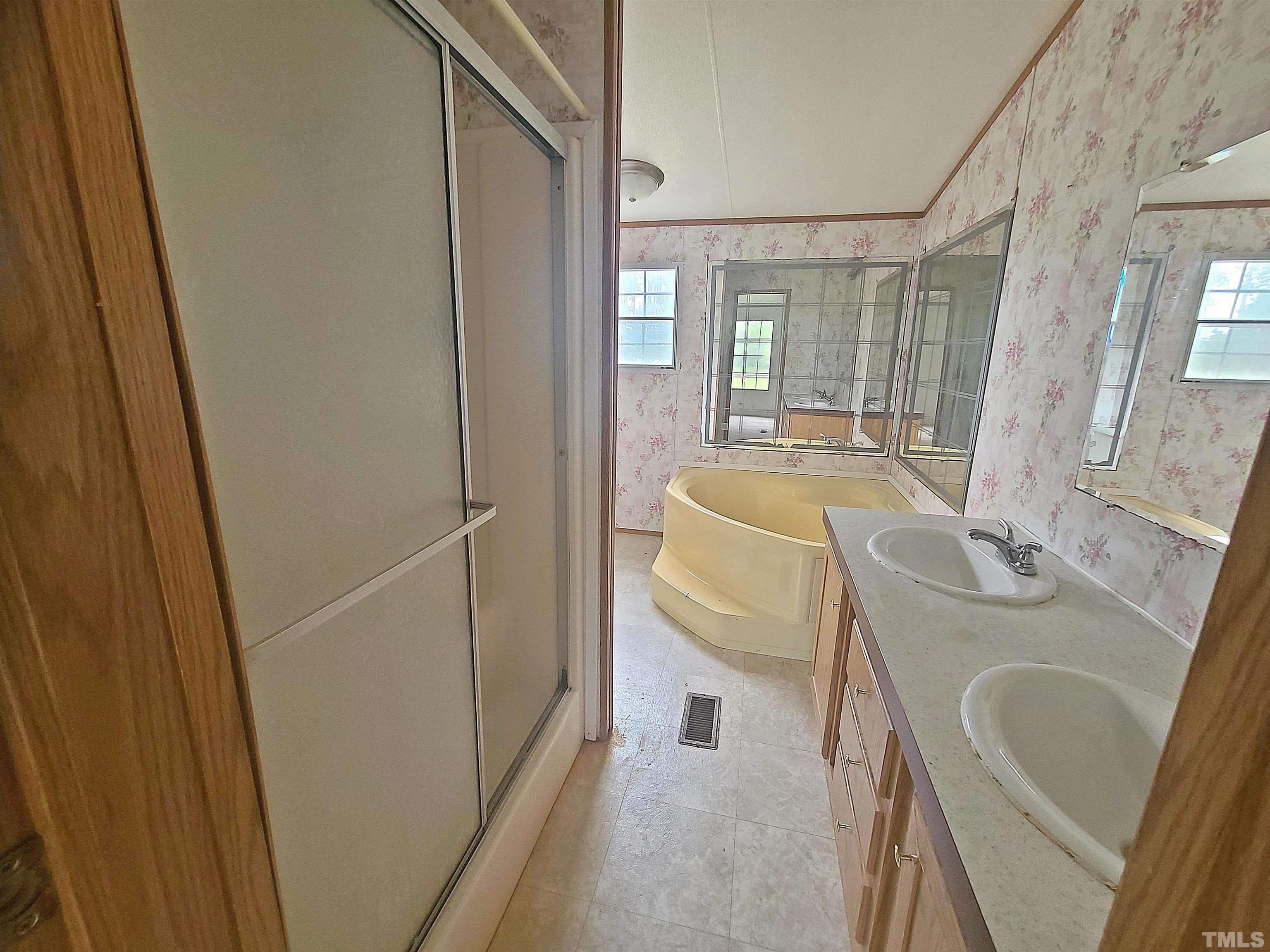 95 Moore Perkerson Road Spring Hope, NC 27882 - Photo 13 of 31 a bathroom with sink a mirror a bathtub and shower