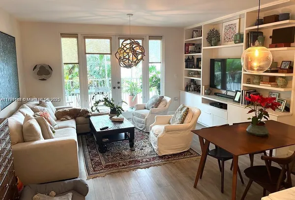 a living room with furniture two window and wooden floor