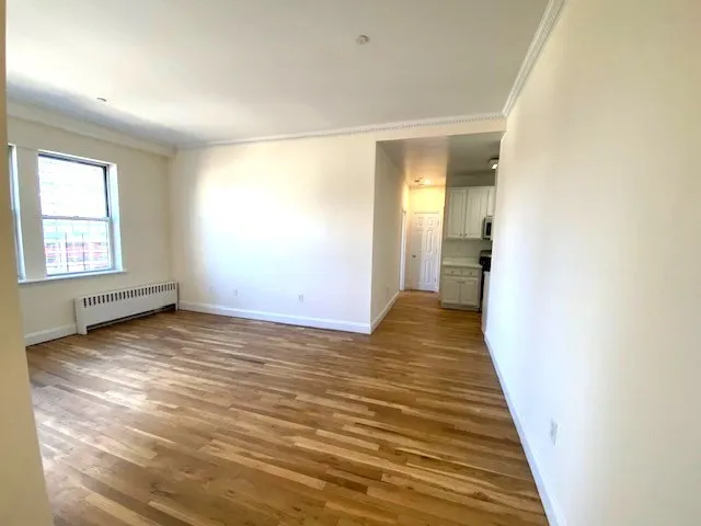 a view of a room with wooden floor and window