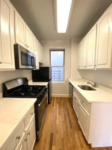 a kitchen with a stove a sink and a microwave
