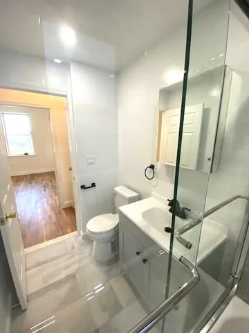 a bathroom with a sink a toilet and shower
