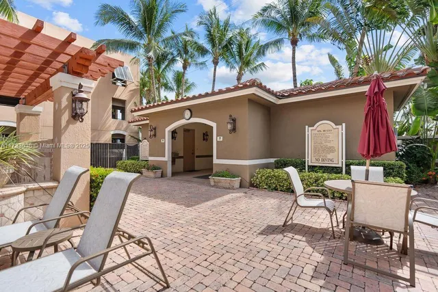 a view of a patio with a table and chairs and potted plants