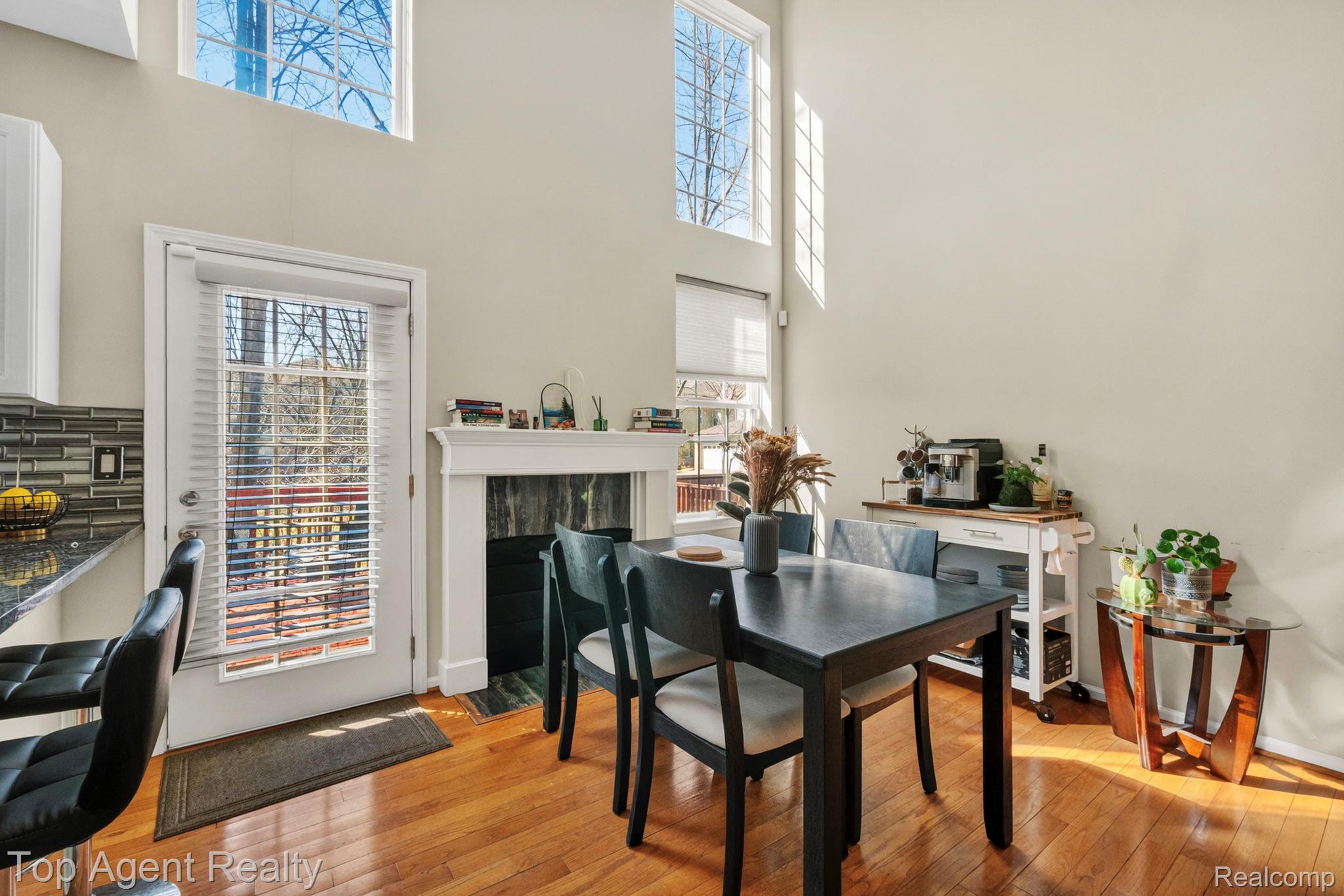 41567 Glade Road, Unit 20 Canton, MI 48187 - Photo 11 of 47 Dining room featuring light wood finished floors, a high ceiling, and a fireplace