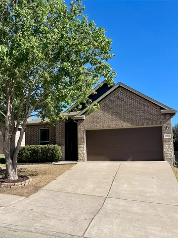 a front view of house with yard and trees around