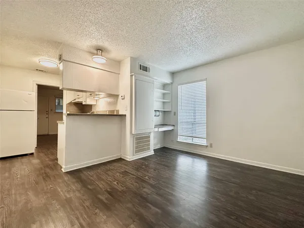 a view of a kitchen with wooden floor and electronic appliances
