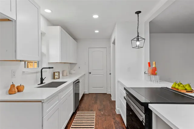 a kitchen that has a lot of cabinets in it and wooden floors