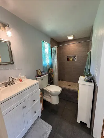 a bathroom with a sink and mirror with toilet