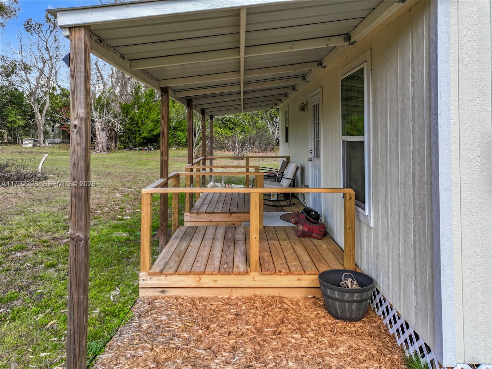 3725 Southwest 162nd Street Archer, FL 32618 - Photo 39 of 48 a view of roof deck with table and chairs potted plants with wooden floor and floor to ceiling window