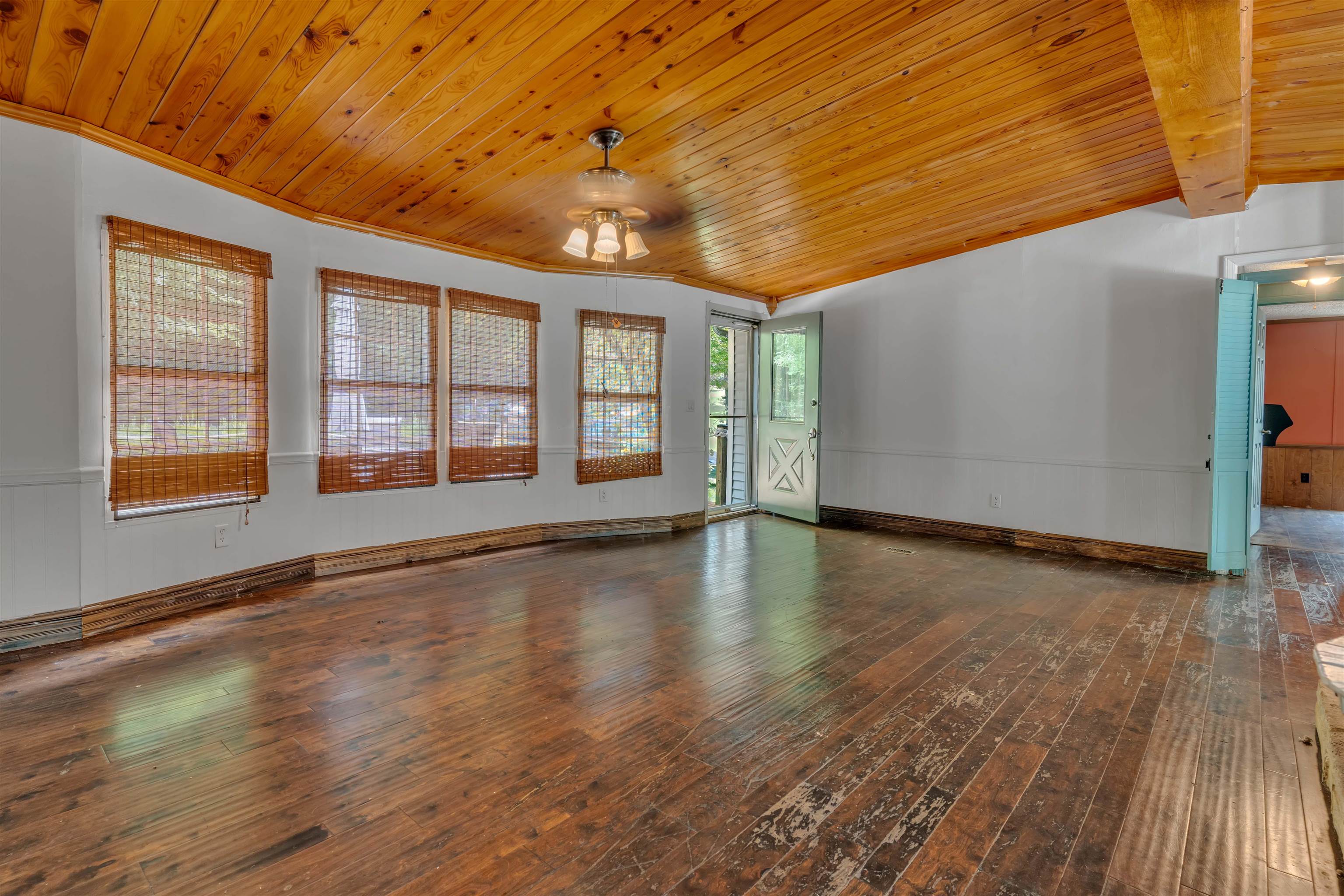 328 Cates Road Halls, TN 38040 - Photo 10 of 36 Wood-finish flooring, wood plank ceiling, exposed wood beam, multiple windows, and a ceiling fan with light fixture